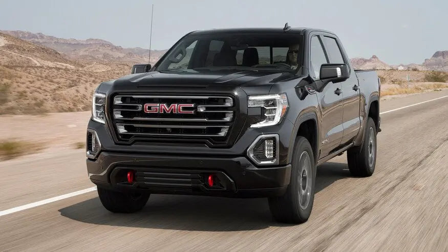 Gen5DIY DRL override harness installed on a 2019 GMC Sierra 1500 AT4, front three-quarter view with active running lights.